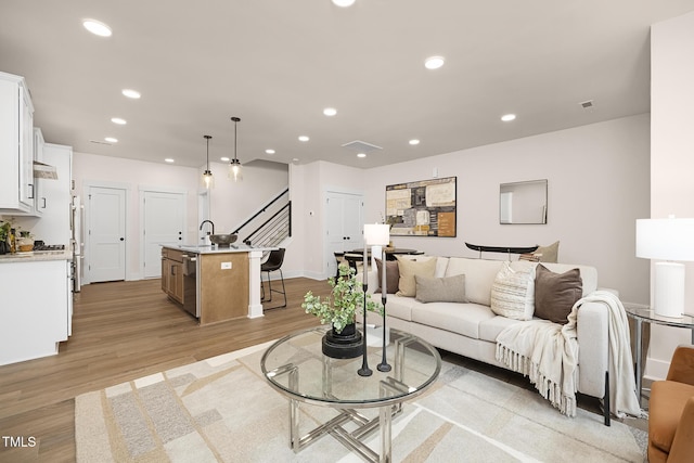 living room featuring sink and light hardwood / wood-style floors