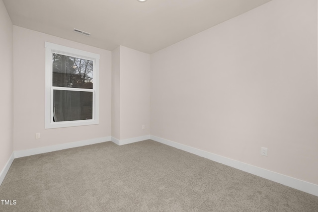 spare room featuring light colored carpet