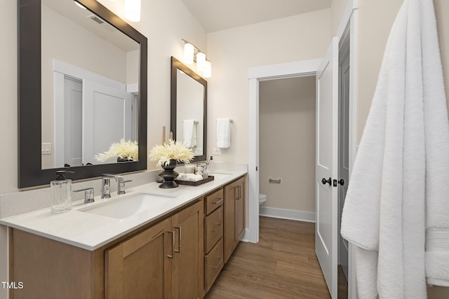 bathroom featuring vanity, hardwood / wood-style flooring, and toilet