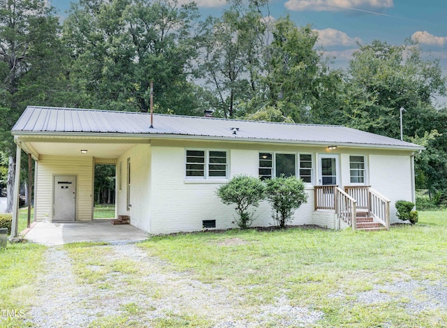 ranch-style home with a carport and a front lawn