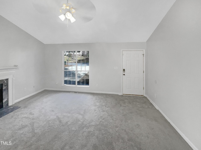 unfurnished living room with ceiling fan, lofted ceiling, carpet flooring, and a high end fireplace