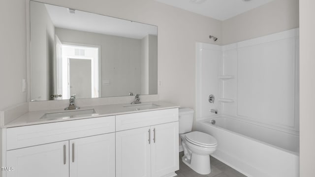 full bathroom featuring washtub / shower combination, vanity, and toilet