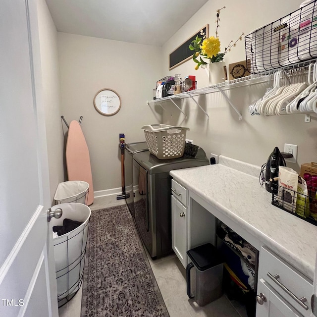 clothes washing area featuring cabinets and washing machine and dryer