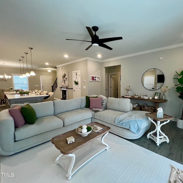 living room featuring crown molding, ceiling fan with notable chandelier, and hardwood / wood-style floors