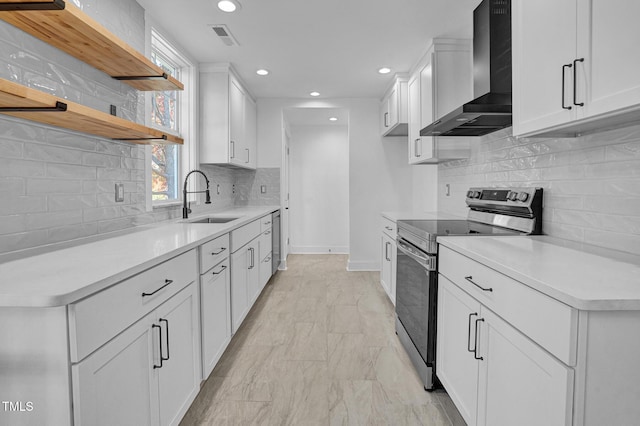 kitchen featuring sink, appliances with stainless steel finishes, backsplash, white cabinets, and wall chimney exhaust hood