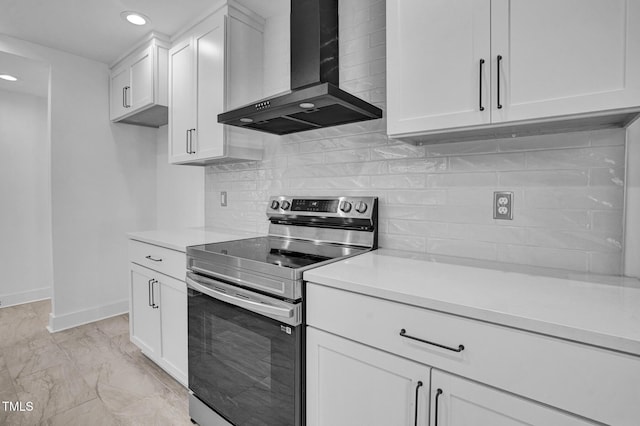 kitchen featuring white cabinetry, decorative backsplash, stainless steel electric range, and wall chimney range hood