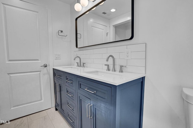 bathroom featuring vanity and backsplash