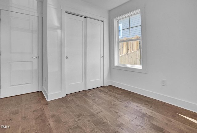 unfurnished bedroom featuring hardwood / wood-style flooring and a closet