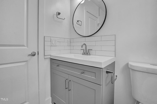 bathroom with tasteful backsplash, vanity, and toilet