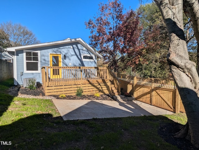 back of property featuring central AC unit, a yard, a deck, and a patio area