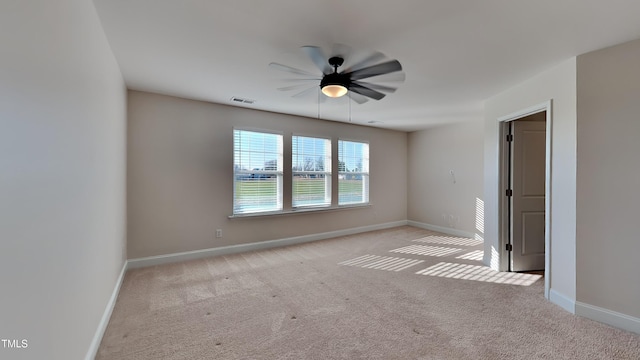 spare room with ceiling fan and light carpet