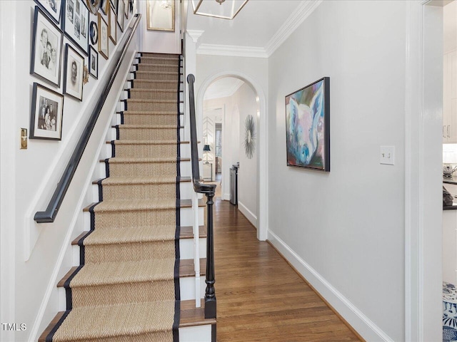 staircase featuring crown molding and hardwood / wood-style floors