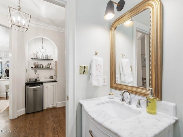 bathroom with vanity, wood-type flooring, a chandelier, and crown molding