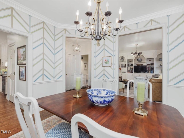 dining area featuring ornamental molding, wood-type flooring, built in features, and a notable chandelier