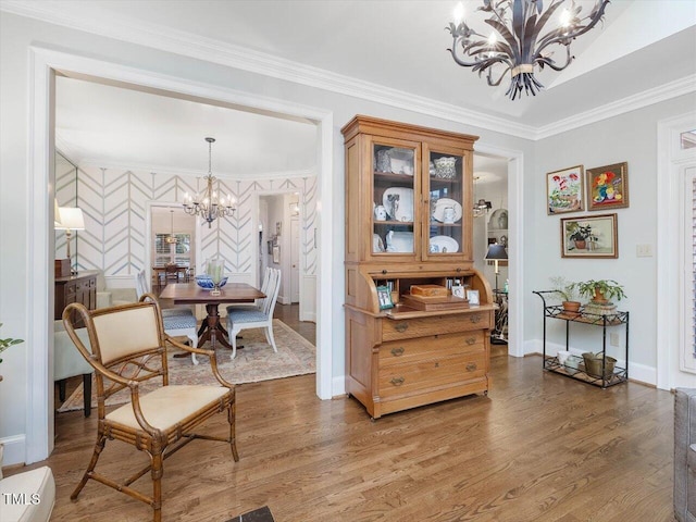 dining space featuring hardwood / wood-style flooring, crown molding, and a chandelier