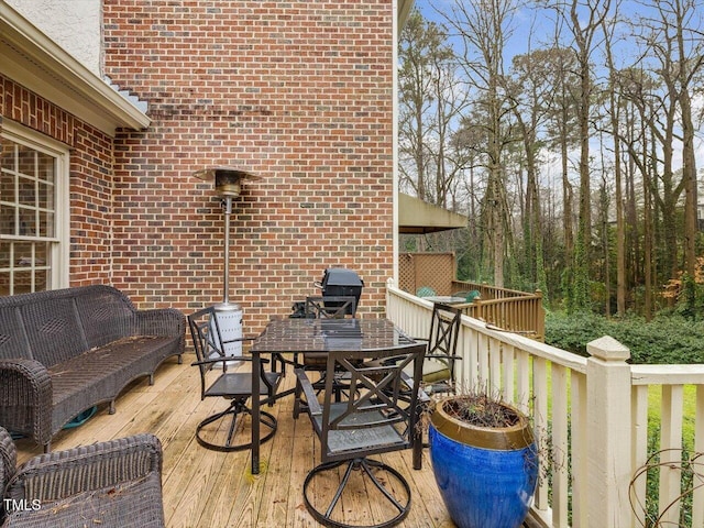 wooden deck featuring an outdoor living space and a grill