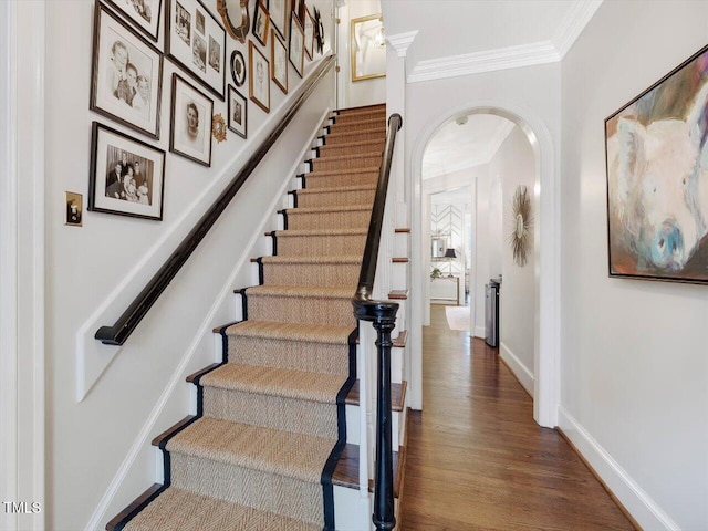 stairway with hardwood / wood-style floors and crown molding