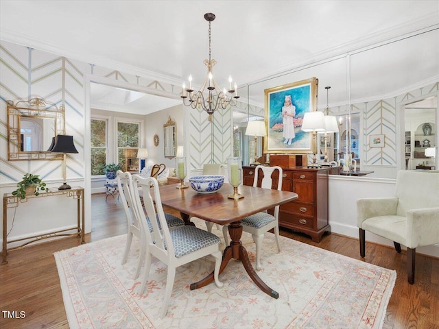 dining area with an inviting chandelier, crown molding, and wood-type flooring