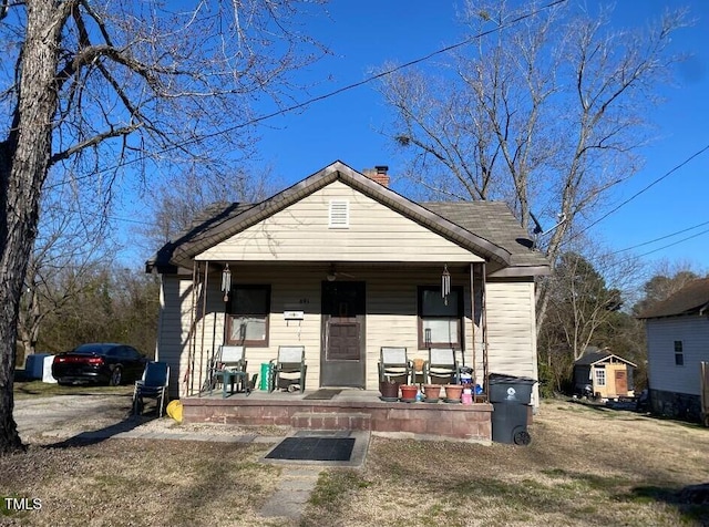 bungalow featuring a chimney and a porch