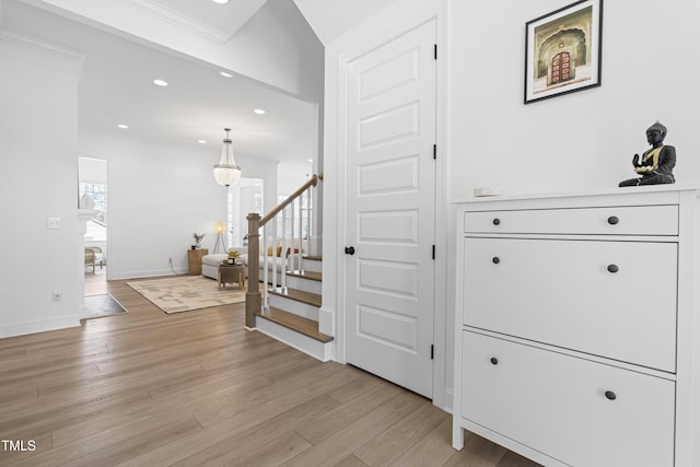 hallway featuring stairs, light wood finished floors, baseboards, and recessed lighting