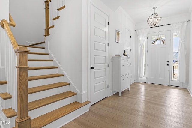 entrance foyer with light wood-style floors, a healthy amount of sunlight, and stairway