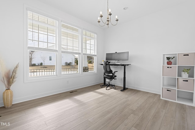 home office featuring a notable chandelier, baseboards, visible vents, and wood finished floors