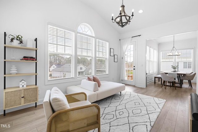 interior space featuring lofted ceiling, an inviting chandelier, light wood-style flooring, and baseboards