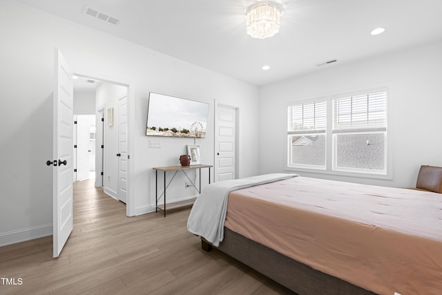 bedroom featuring light wood-type flooring, visible vents, baseboards, and recessed lighting