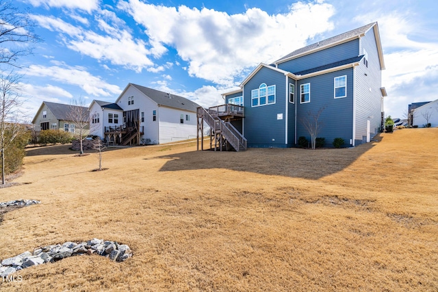 back of property with a residential view, a deck, and stairway