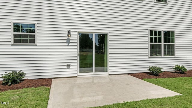 entrance to property with a yard and a patio area