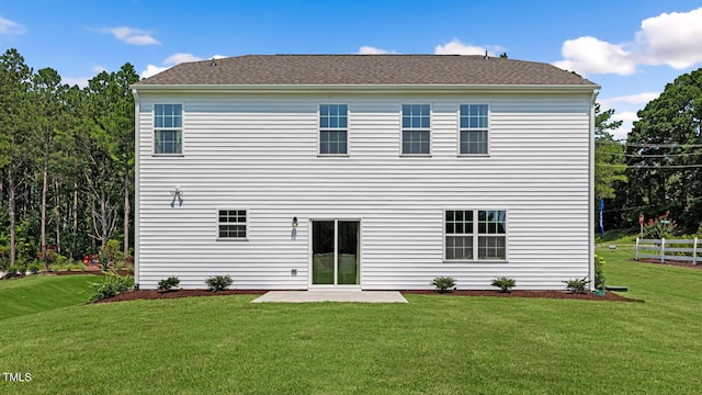 rear view of house featuring a yard and a patio