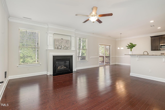 unfurnished living room with crown molding, dark hardwood / wood-style floors, and ceiling fan