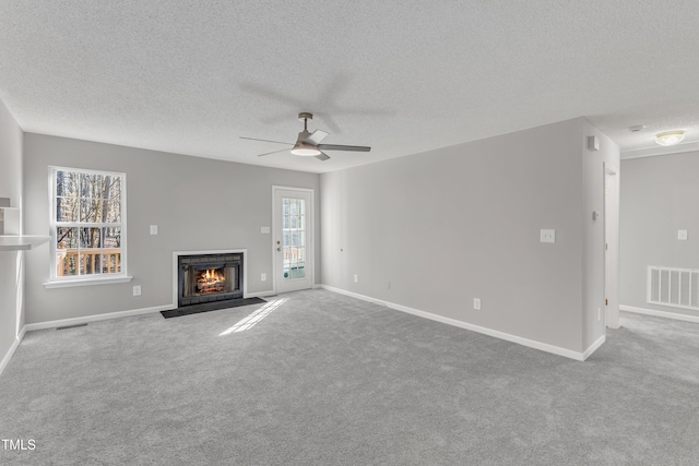 unfurnished living room featuring light carpet, a textured ceiling, and ceiling fan