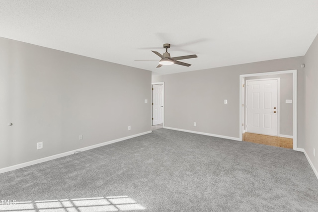 empty room featuring a textured ceiling, carpet floors, and ceiling fan