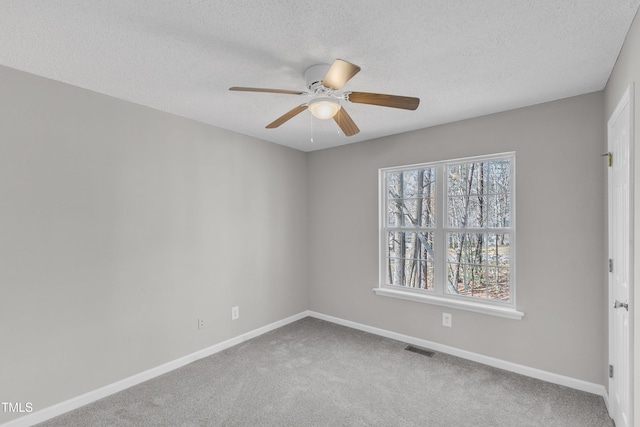 carpeted spare room with ceiling fan and a textured ceiling