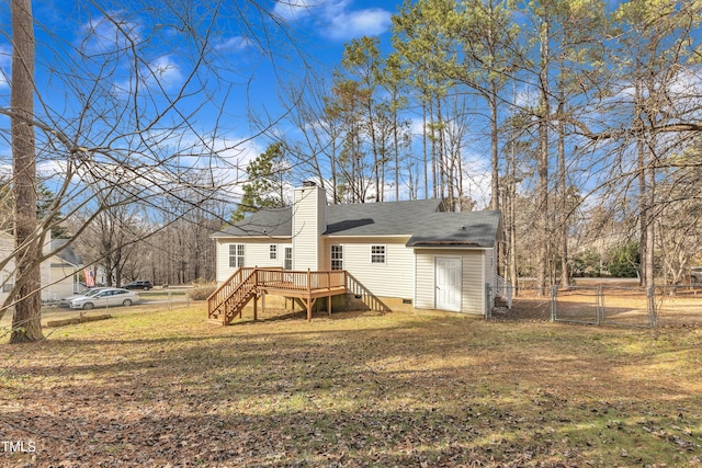 rear view of house with a wooden deck and a yard