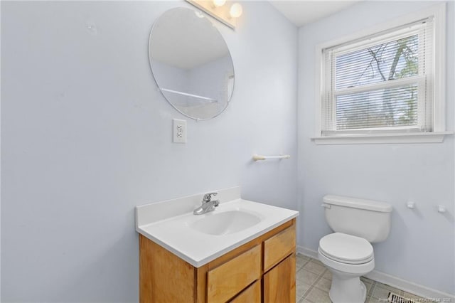 bathroom featuring baseboards, vanity, and toilet