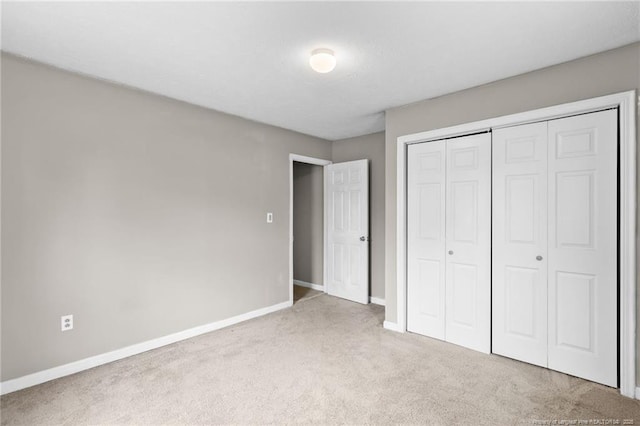 unfurnished bedroom featuring a closet, carpet flooring, and baseboards