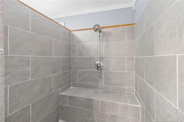 bathroom featuring crown molding and tiled shower