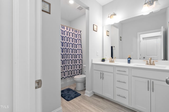 bathroom with toilet, hardwood / wood-style flooring, curtained shower, and vanity
