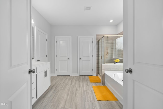 bathroom featuring vanity and independent shower and bath