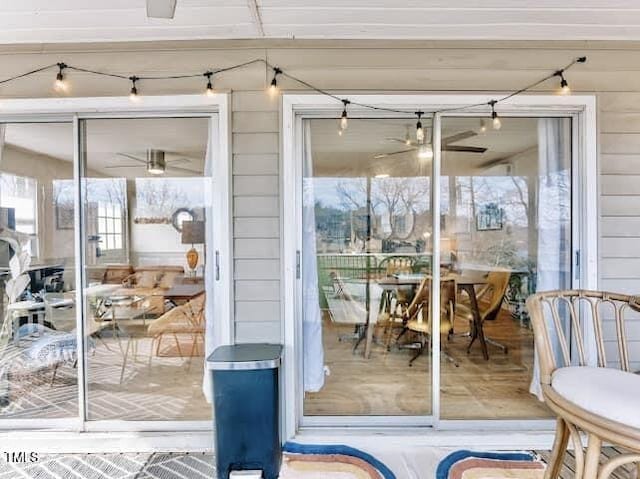 entryway featuring plenty of natural light, ceiling fan, and wood walls