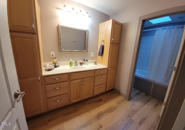 full bathroom with shower / bath combo with shower curtain, vanity, and wood finished floors