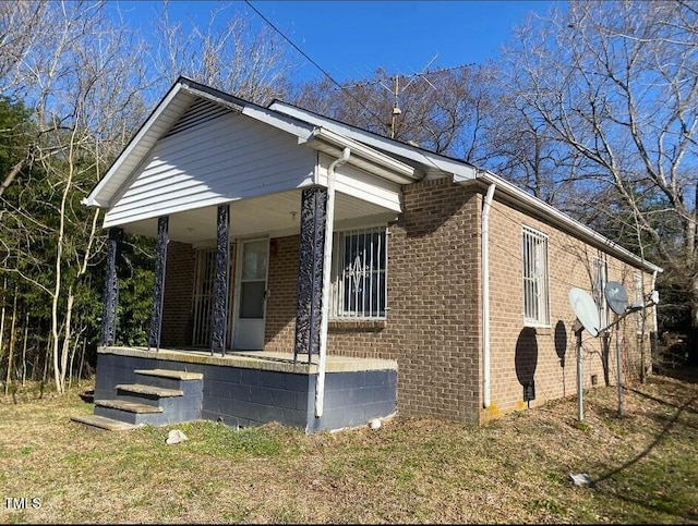 view of side of property with covered porch and brick siding