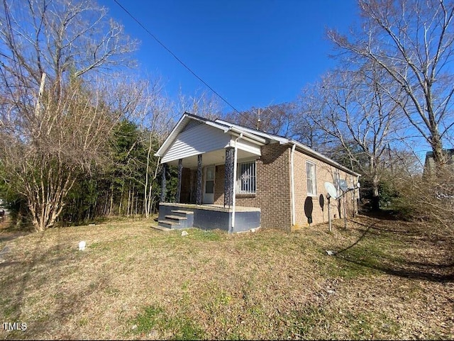 view of side of property with covered porch and brick siding