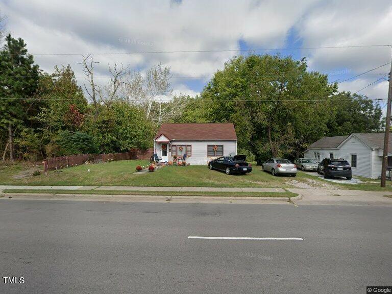 view of front of home featuring fence and a front lawn