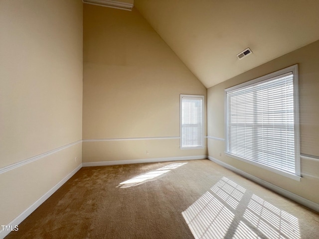 empty room featuring light colored carpet and high vaulted ceiling