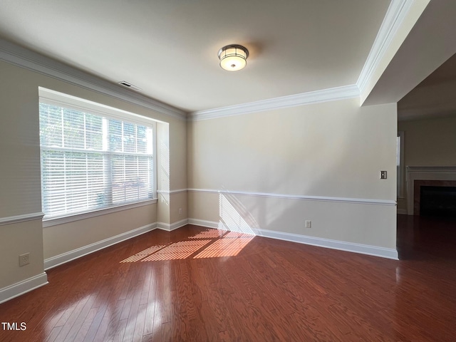 empty room with crown molding and dark hardwood / wood-style floors