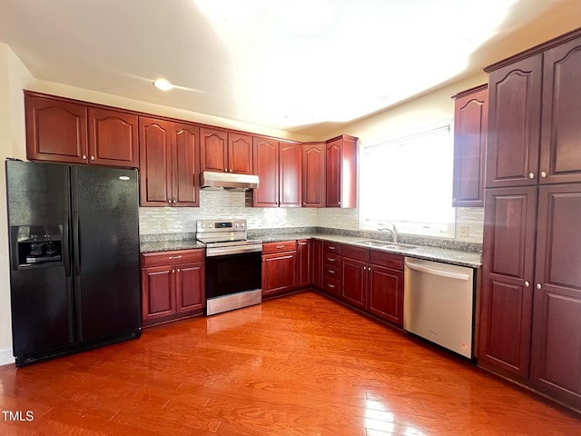 kitchen featuring stainless steel appliances, tasteful backsplash, sink, and dark hardwood / wood-style flooring