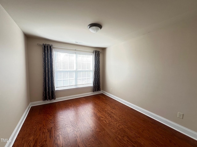 spare room with dark hardwood / wood-style flooring